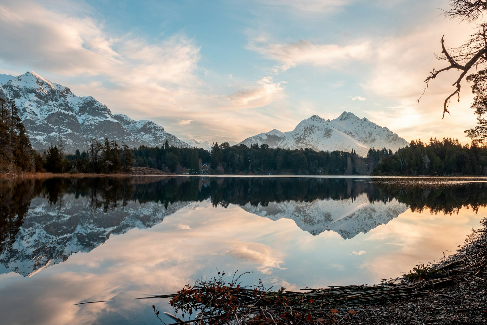 Meer met bergen en bossen bij Bariloche onder witte wolken